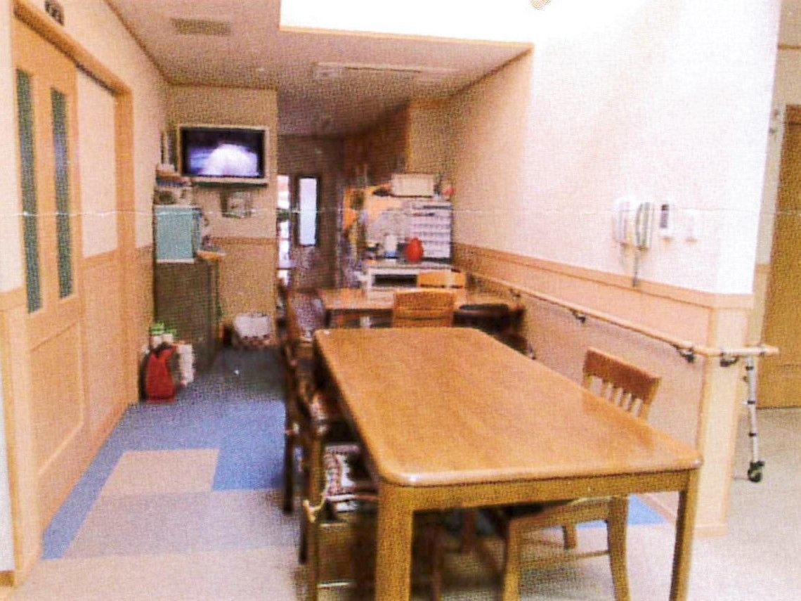 テレビや木製のダイニングテーブルが置かれた家庭的な雰囲気の食堂。