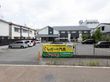 施設の前には広い駐車スペースがあり、７台の車が駐車されているが、まだまだ余裕がある。駐車スペースの端には灌木が何本が植えられている。