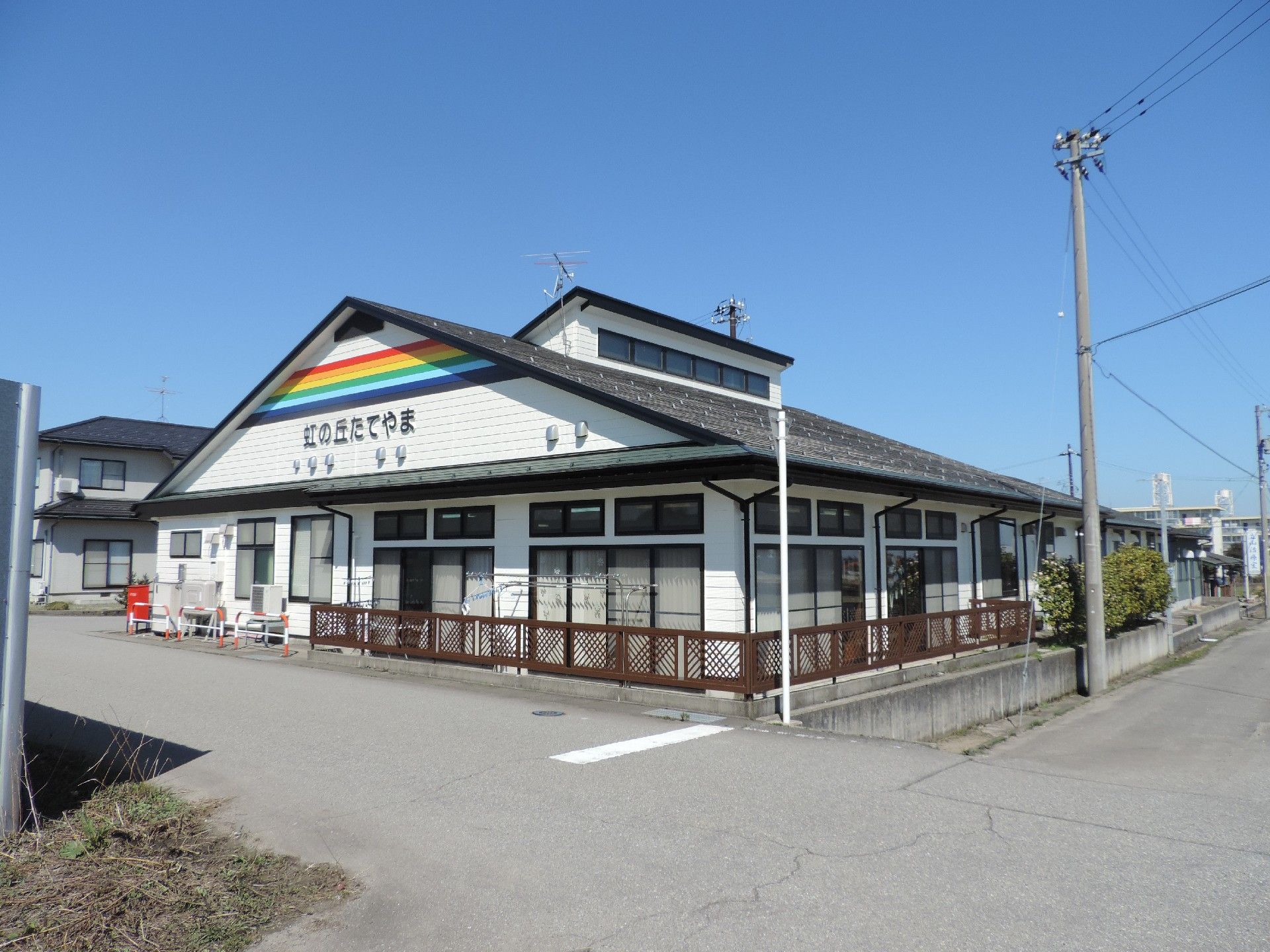 三角屋根のアットホームな雰囲気の施設。周辺には住宅がある。