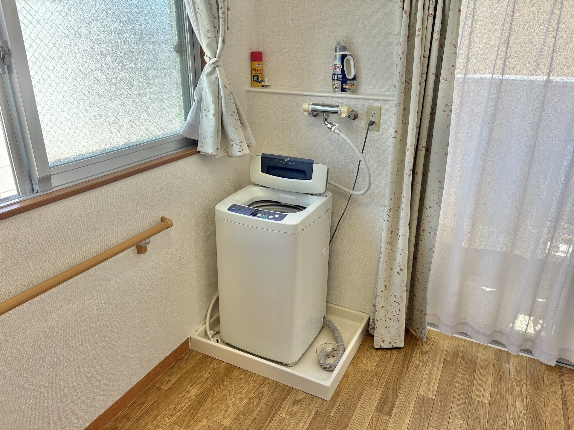 カルテのようなものを見ながら話しているピンクのエプロンを付けた若い女性スタッフと高齢女性。