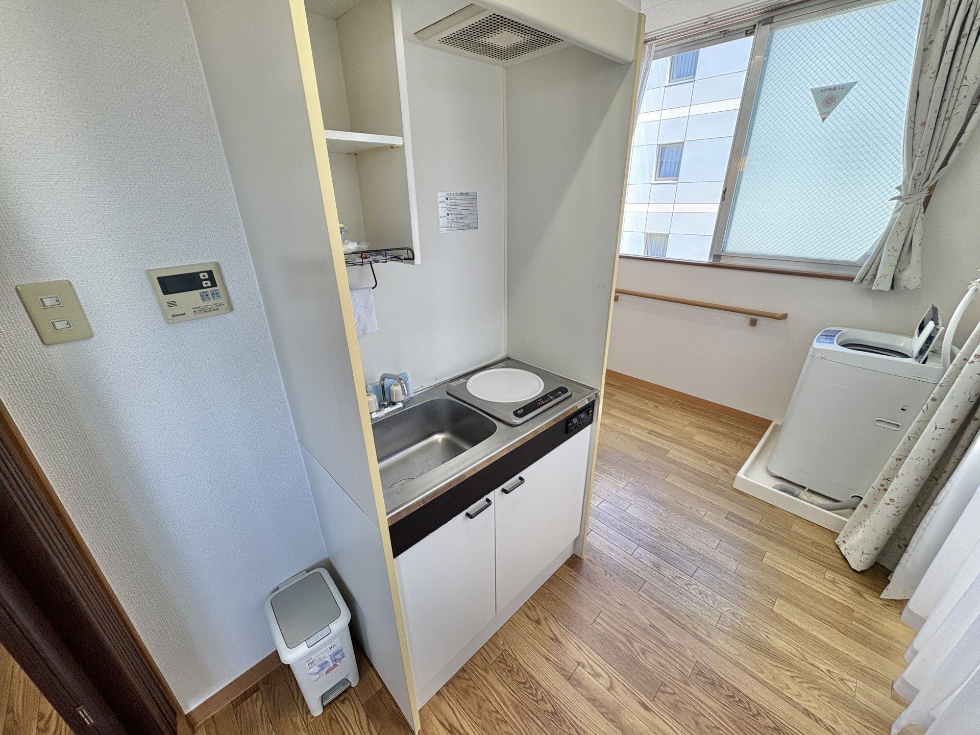 ブルーのユニフォームを着た男性スタッフが白い服を着た高齢女性と体操をしている。