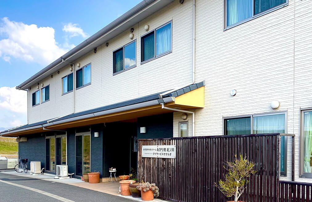 紺色と白い外壁で三角屋根の2階建て建築物
