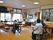 フローリングの共有スペースでは数名の入居者が思い思いの場所で過ごしていて、スタッフが付き添っている。