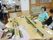 そうめん流しを屋内で楽しんでいる入居者たち。それぞれのテーブルにそうめん流しのセットが置かれている。