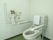 温水洗浄便座が採用された清潔感のあるトイレである。操作ボタンは壁に取り付けられており、押しやすくなっている。