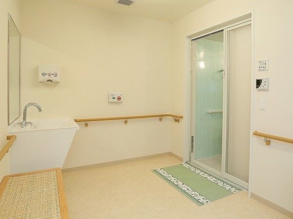 ベンチや車いす対応の洗面所、手すりが付いた脱衣所。浴室のドアの前にはグリーンのマットが敷かれ、きれいに掃除が行き届いている。