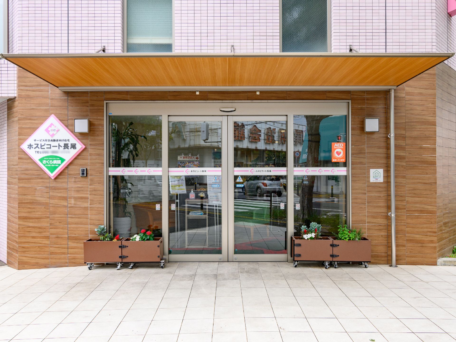 入り口付近に植物が設置された介護施設の外観