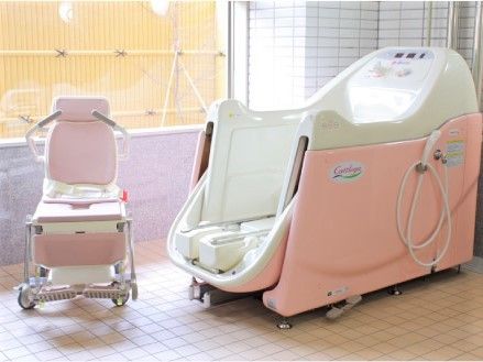 座ったまま入浴可能な機械浴が設置された浴室には大きな窓が付き、外には和風庭園がある。
