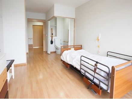 フローリングで、ベッドやトイレが付いた居室にはタンスや小物が持ち込まれている。