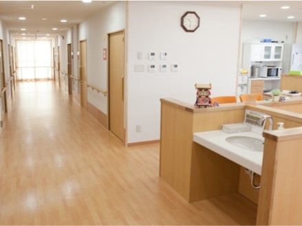 まっすぐな廊下には手すりが付き、両サイドには居室があり、突き当りには大きな窓が付き明るい雰囲気。