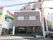 建物２階窓に施設名が記されている。目の前は歩道があるほか、電柱が立っている。建物の１階部分に駐車場がある。