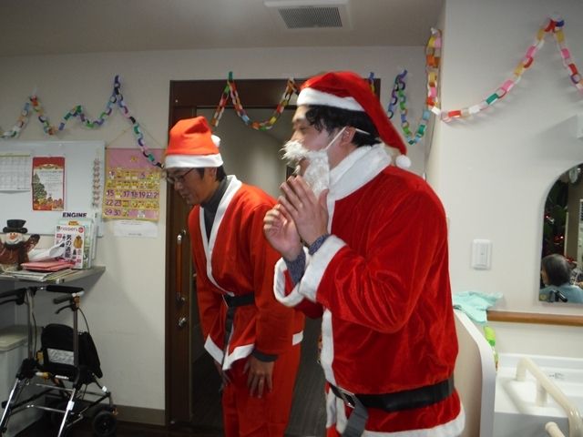 サンタクロースの紛争をした男性スタッフが二人、前に出てクリスマス会を盛りあげている。