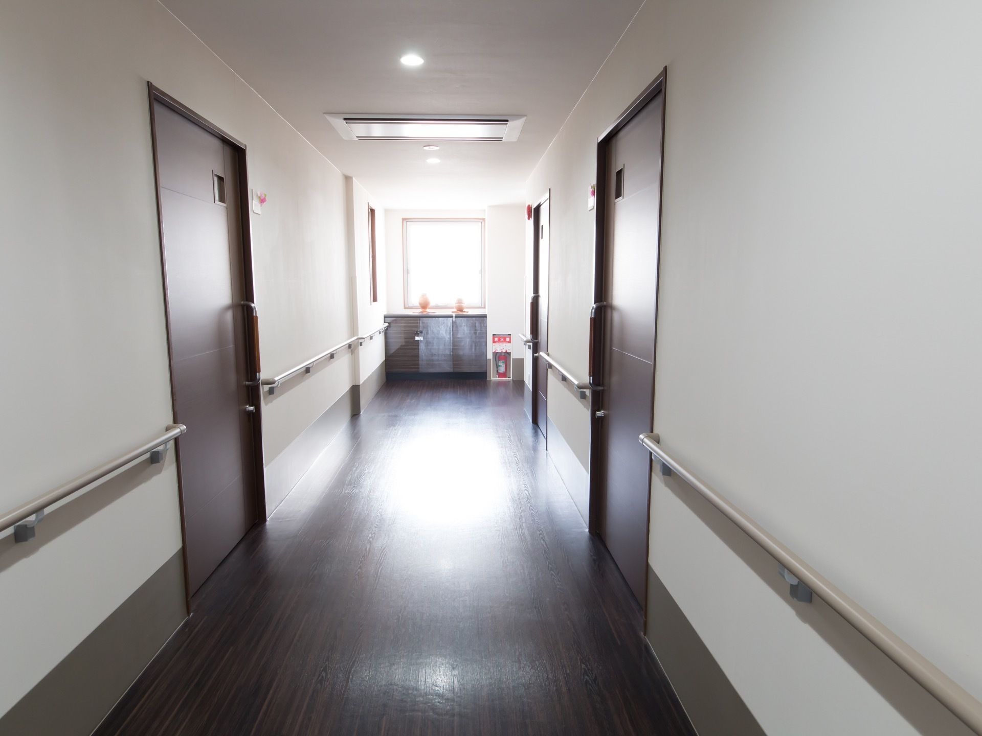 居室が立ち並ぶ廊下で、突き当たりには消火器が置かれている。各部屋には鍵が掛けられるようになっている。