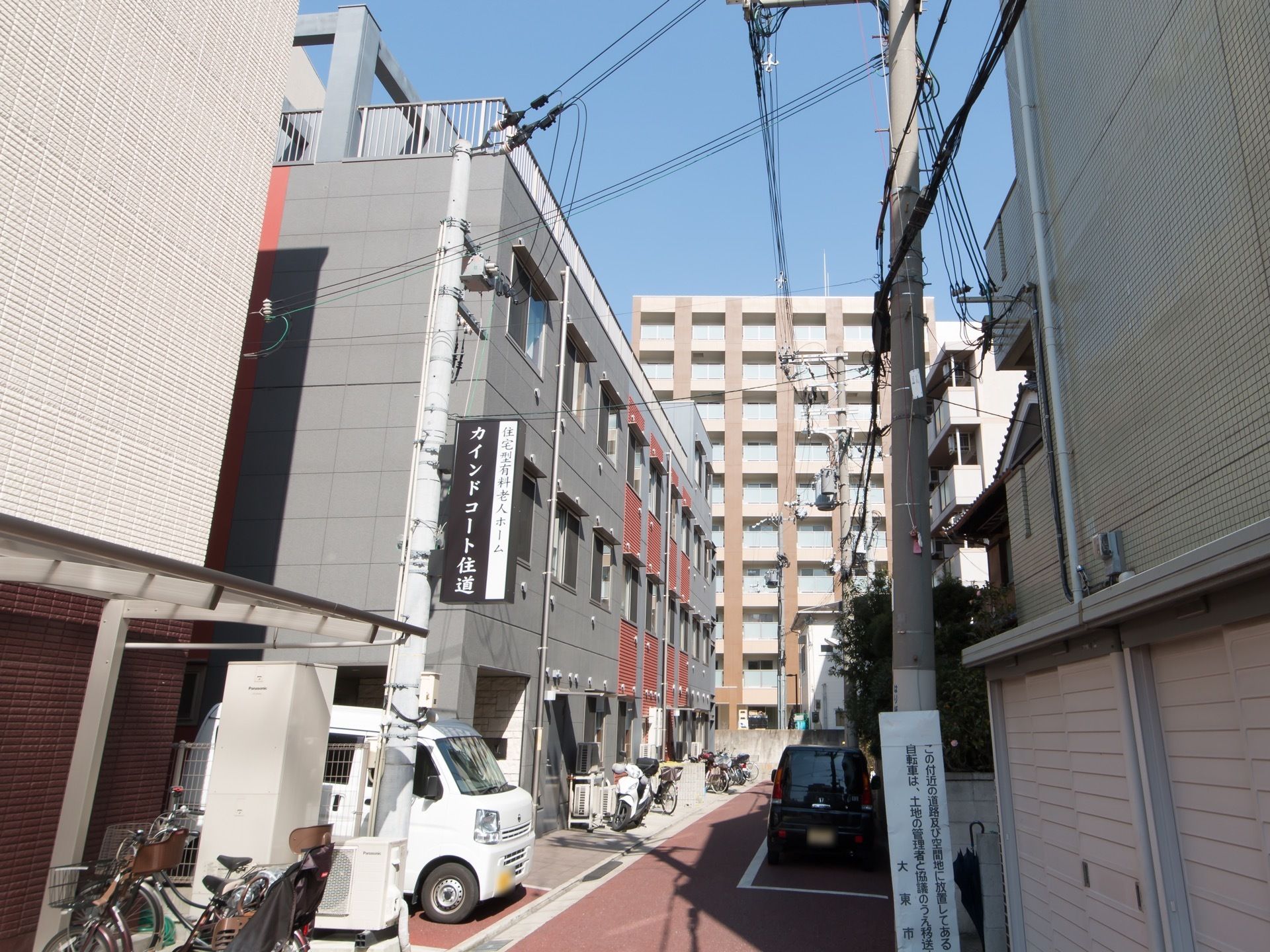住宅街の中に建てられた３階建てのグループホームである。屋上には転落防止のためのフェンスが設置されている。