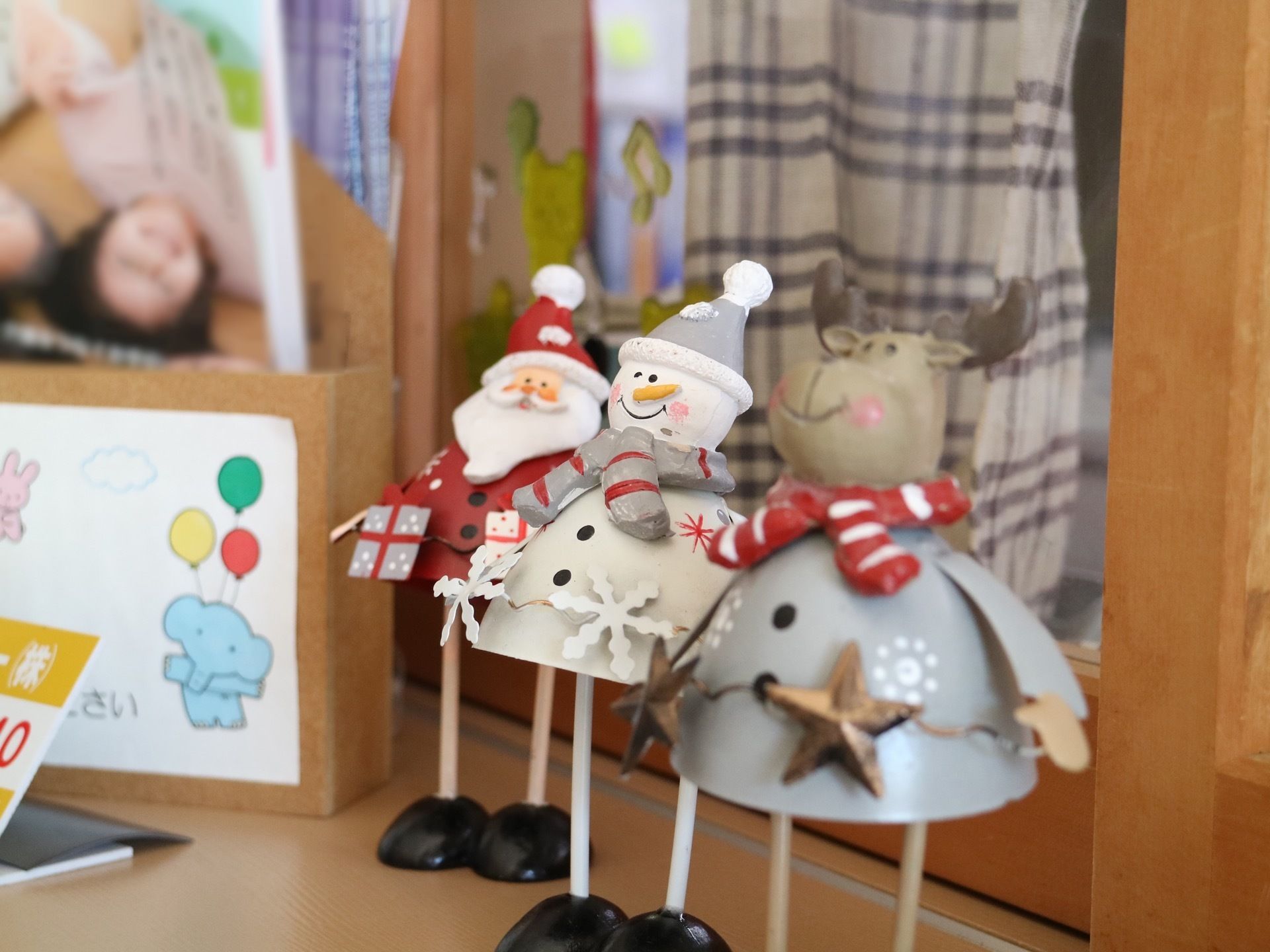 施設案内のパンフレットが置かれている横に、サンタや雪だるまをモチーフにした小さな木製の置物が並べられている。