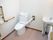 両側に手すりがついたトイレの様子。車いすのまま入れるトイレの写真