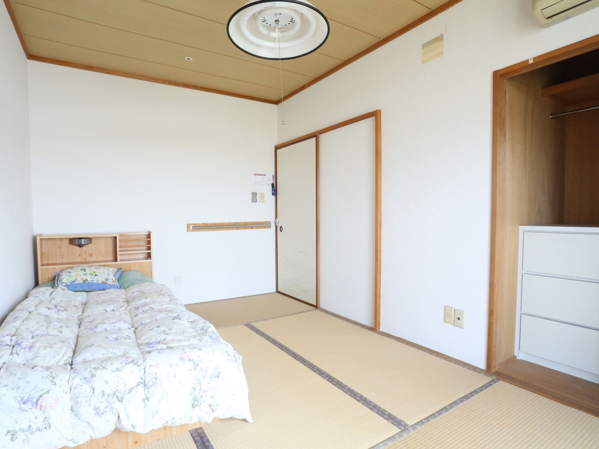 和室風の造りとなっており、畳とふすまが使用されている。壁際にベッドが置かれている。横に収納庫があり、白い３段のチェストが配置されている。