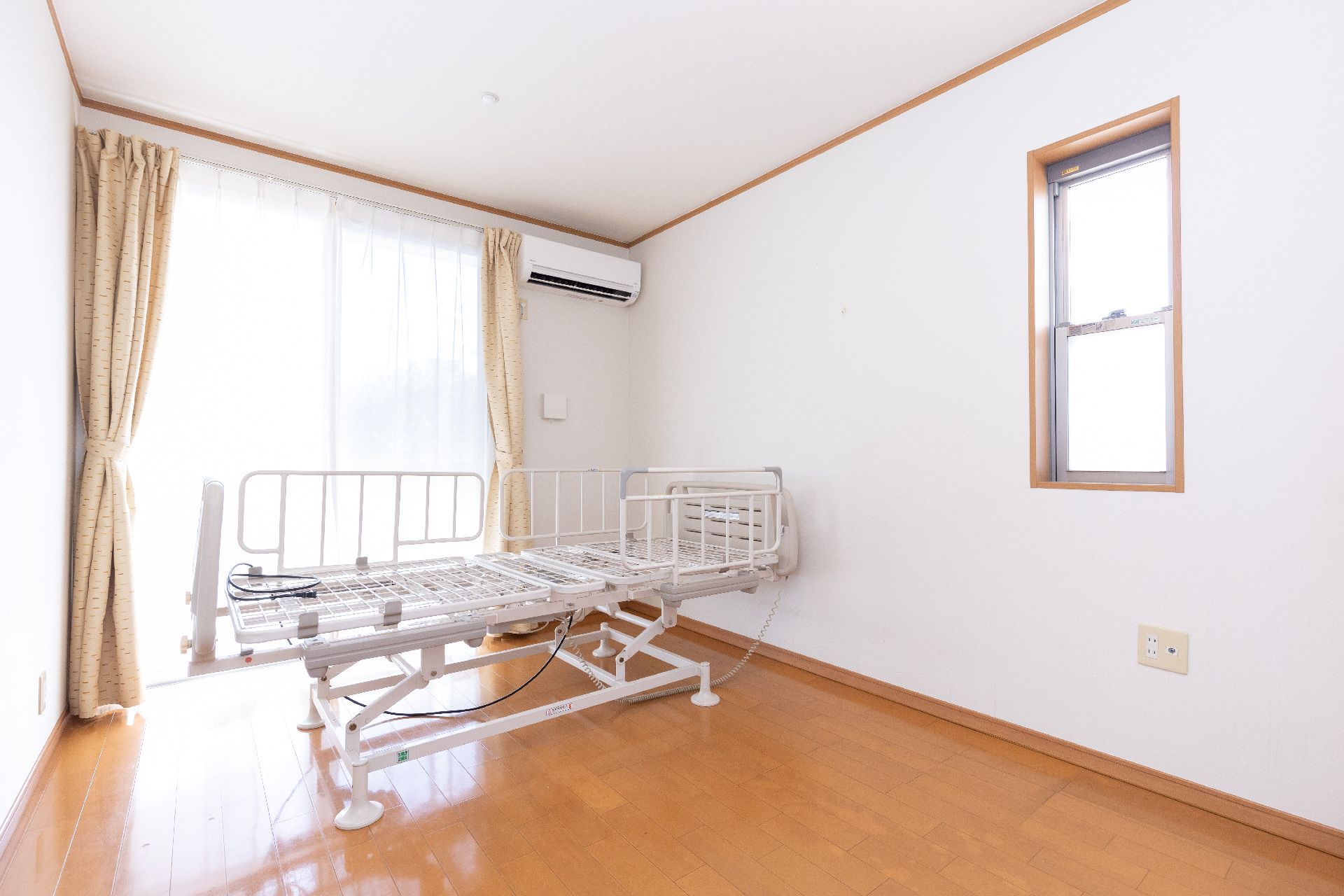 ベッドに寝た状態で食事を摂っている女性と介助しているスタッフの様子
