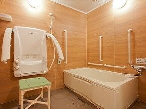 座ったままシャワーを浴びられる介護用設備が整った浴室の様子