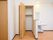 白い壁の部屋に設けられた木製の扉の収納棚