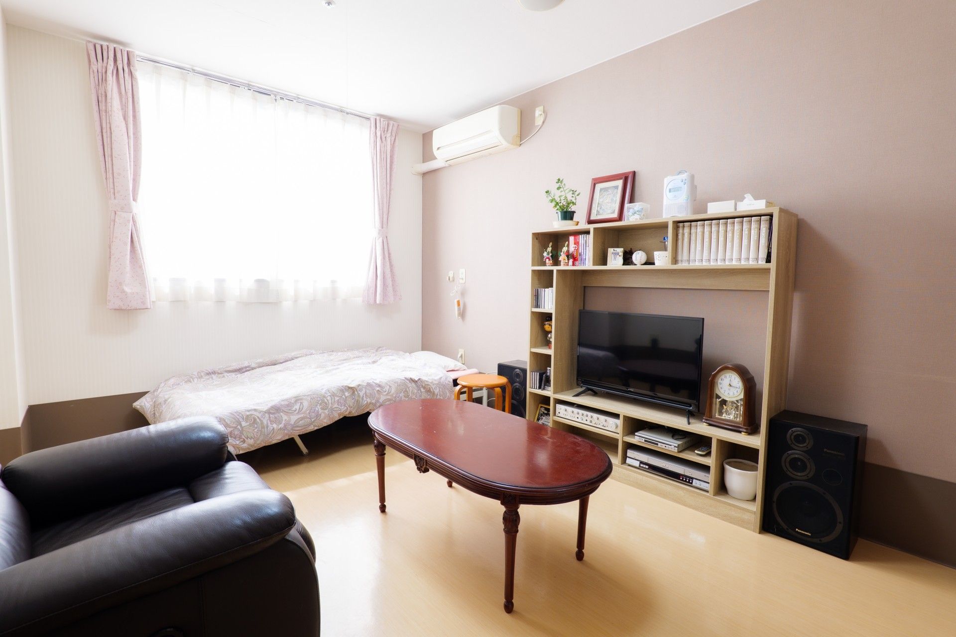 カーテン付きの大きな窓が付いた居室には、照明が付き、家具はまだ置かれていない。日当たり良好。