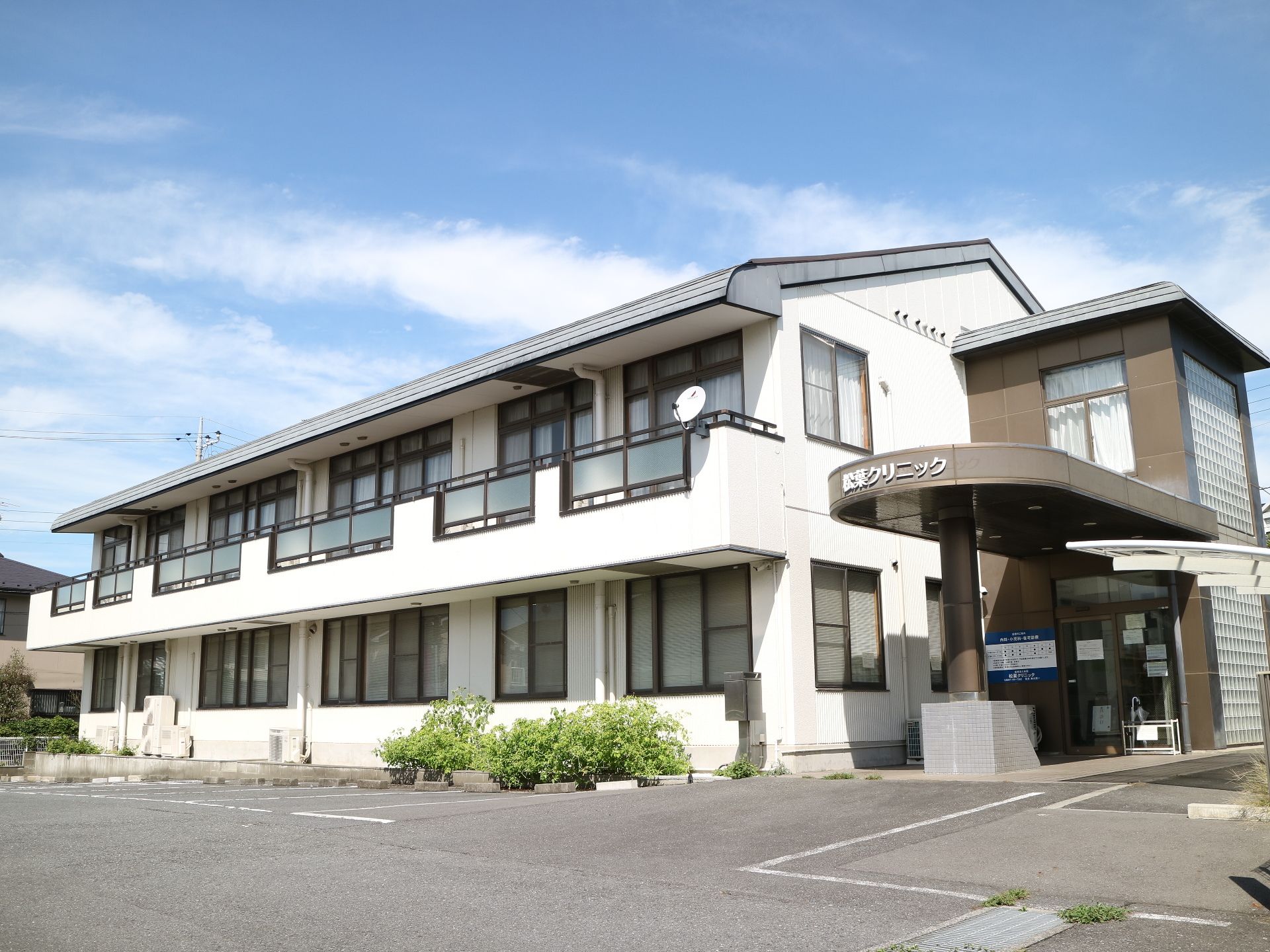 駐車場と駐輪場、庇があり、ベランダがついている二階建ての建物