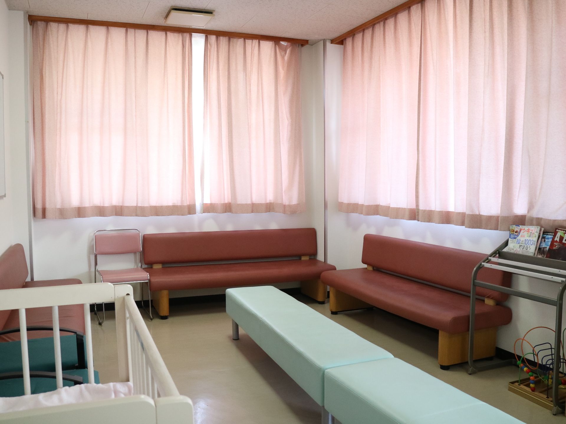 カーテンが閉め切られた部屋に、複数置いてある長い椅子
