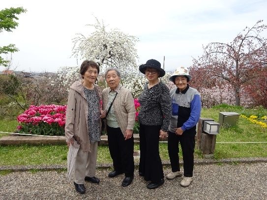カメラに顔を向けて微笑んでいる祖父母と娘、孫が出かけた時の写真