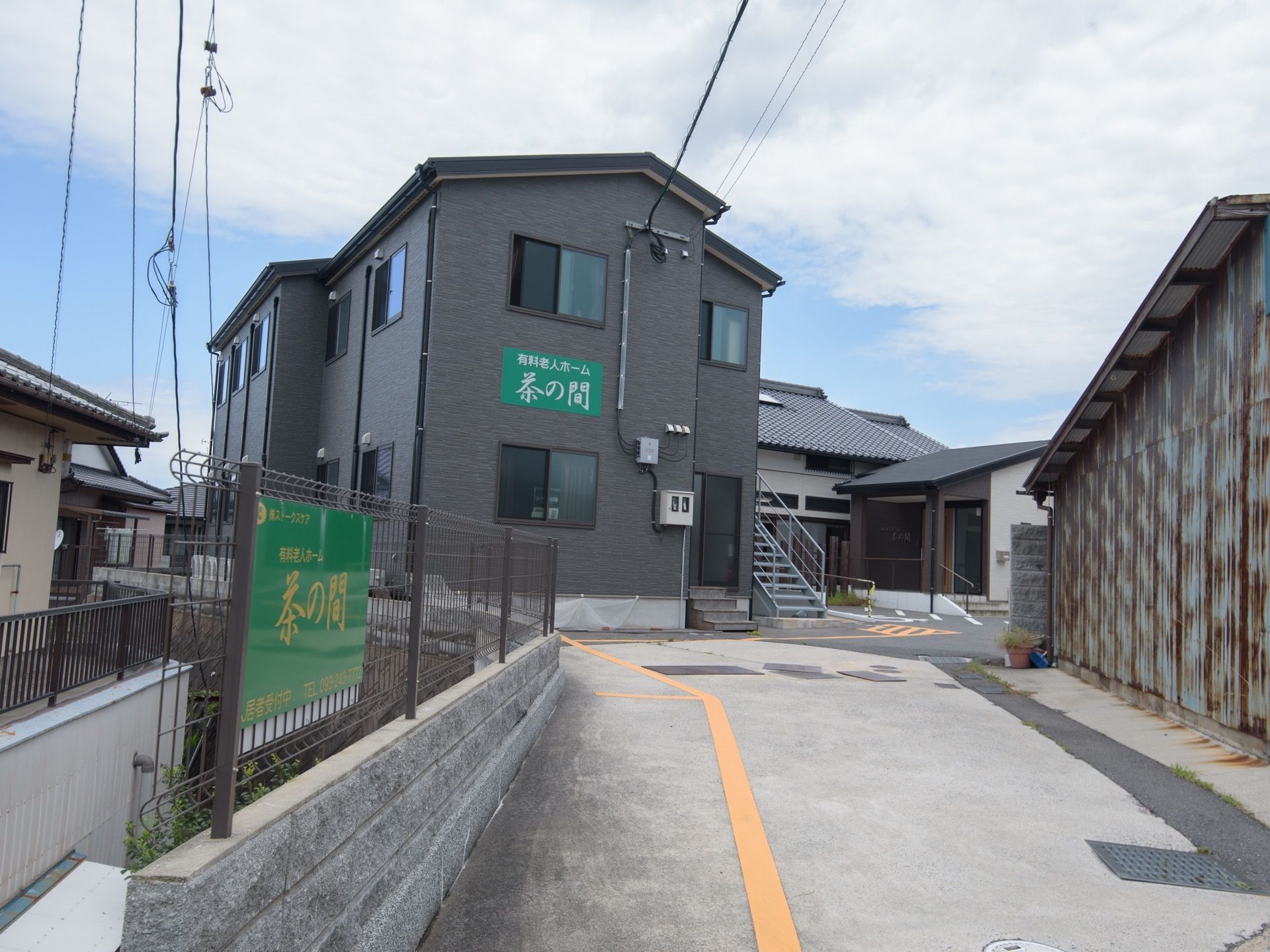 住宅街の中にある２階建ての建物で、外壁に施設名が大きく書かれている。周辺に高い建物がなく、日当たりが良い。