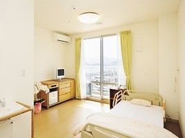 居室内を写した写真。ベッドやタンス、テレビ、エアコンなどの設備が整っている