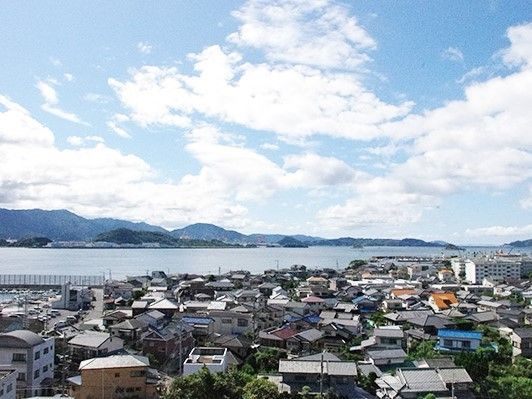 天気の良い日に施設から街並みを見た様子。穏やかな海が続いている様子が分かる
