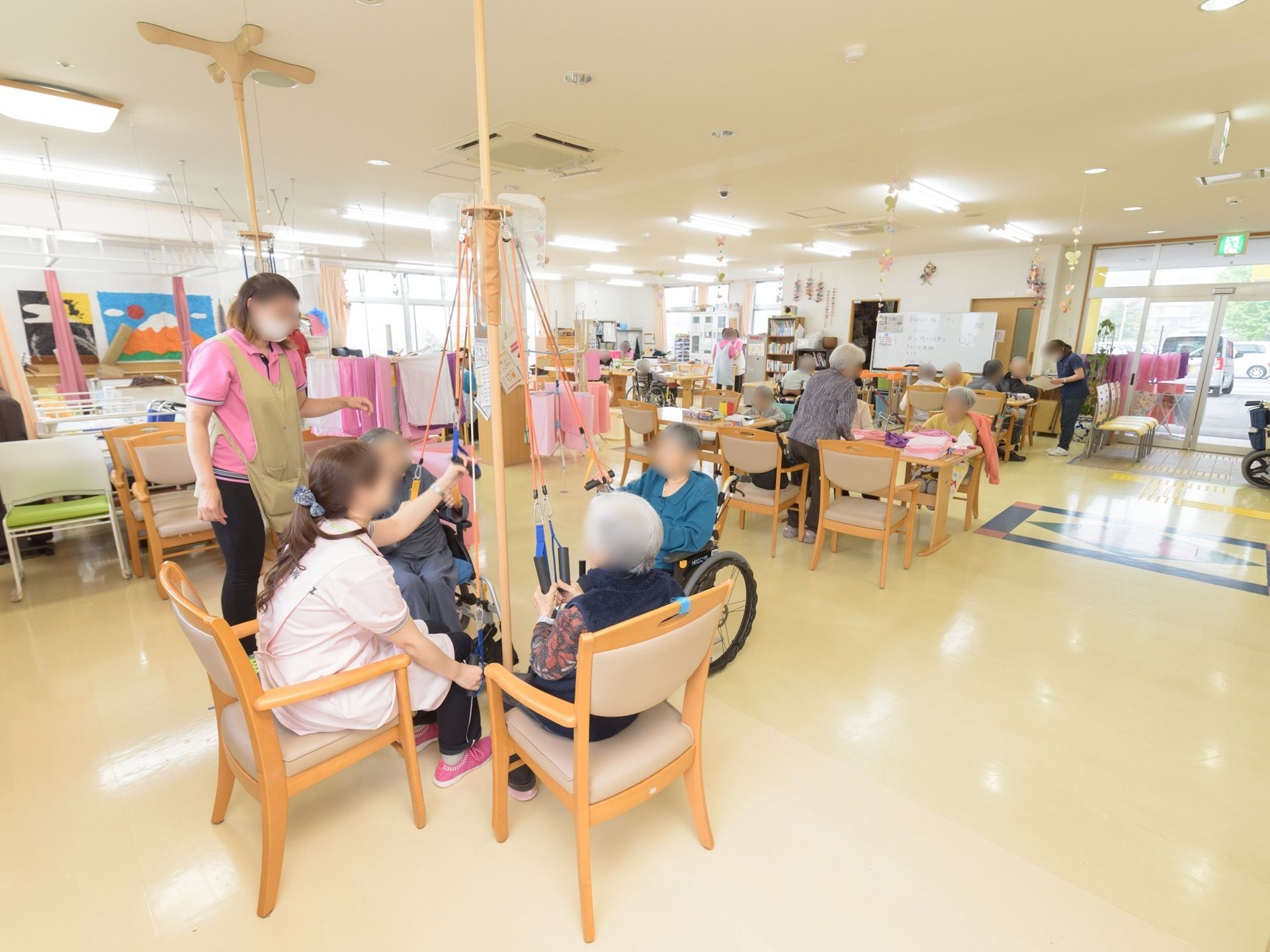 玄関に入ってすぐの所に広いリビングが設けられており、入居者様が活動に励んでいる。運動器具も、複数用意されている。