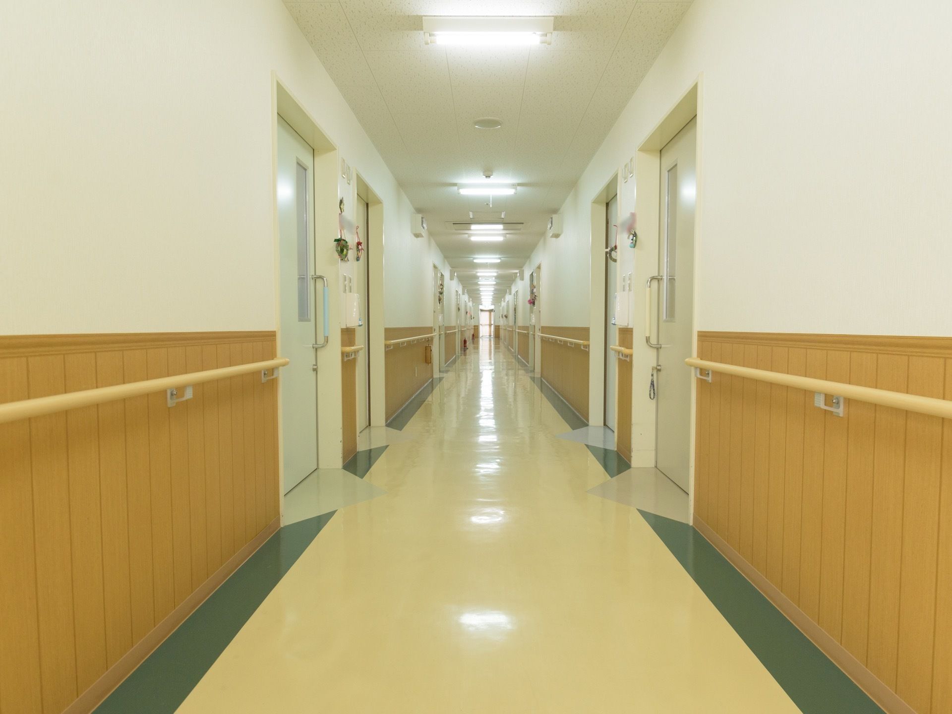 廊下の半分から下は木目で、居室のドアや天井、床は白いため明るい印象がある。居室の入り口付近にネームプレートがある。