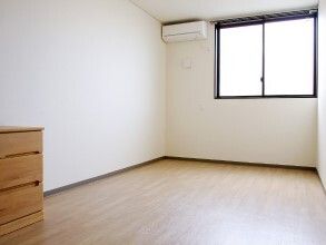 大きな窓にはカーテンはなく、窓のそばにはエアコンが設置され、木製のタンスも置かれているが、入居者の私物はまだ持ち込まれていない。