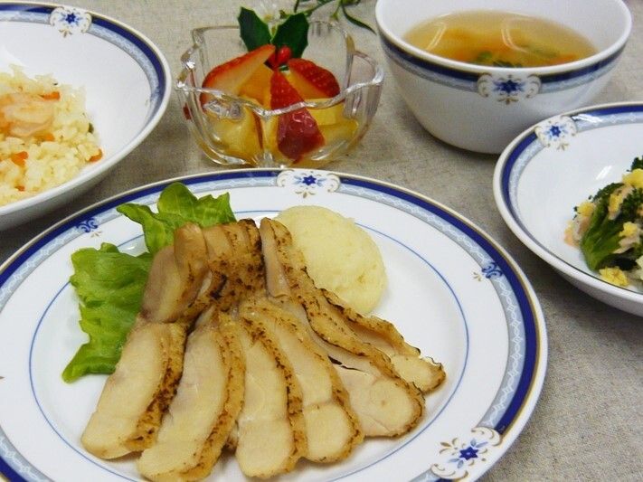 ピラフやチキン、イチゴなどのデザート、スープ、野菜料理が並べられたテーブル。