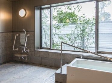 大きな窓が付いた浴室には一人用の浴槽が設置され、浴槽に沿うように手すりが設置されている。
