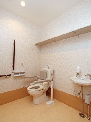 広いトイレ内には背もたれや手すりが付いた便座があり、壁にも手すりや呼び出しボタンが付いている。