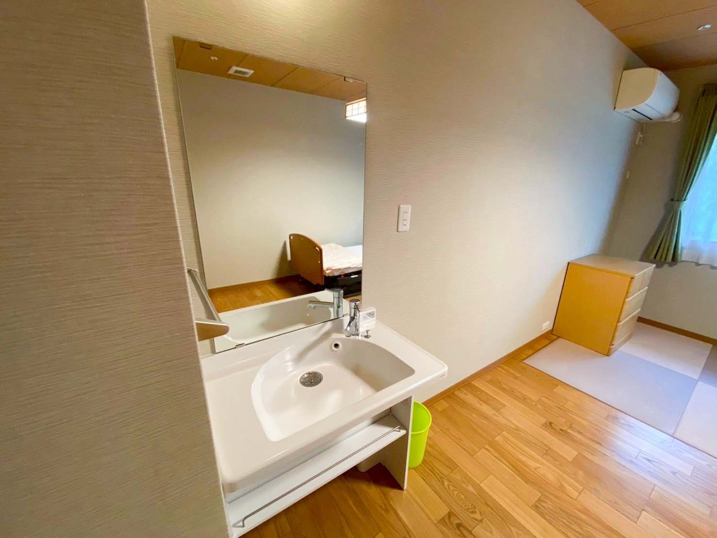 洗面台とベッドのある部屋