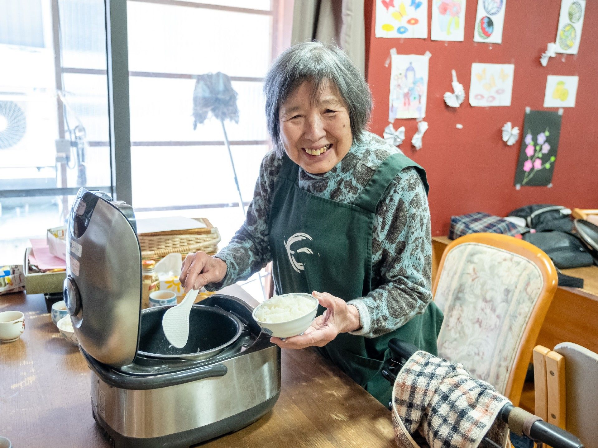 ごはんをよそう高齢者の様子。施設で食事をしているときの一場面