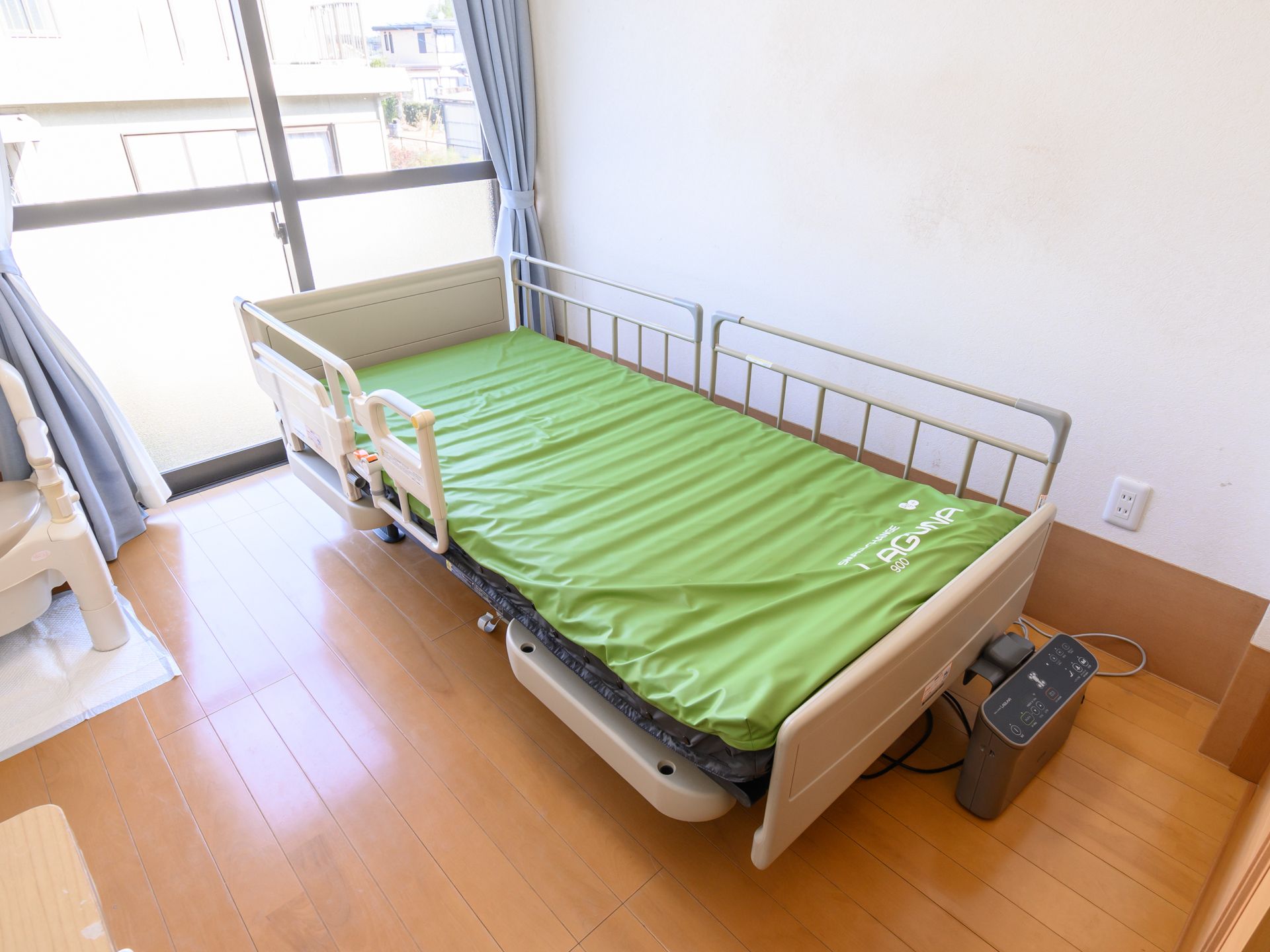 窓があり、介護ベッドが置かれている居室