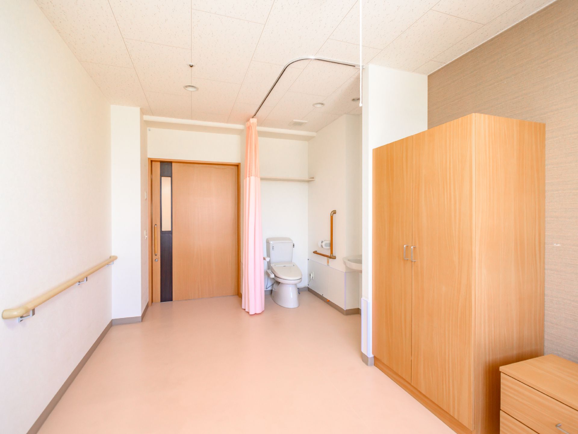 鏡を見ながら笑顔で話している高齢者とそこに寄り添介護スタッフの様子。明るい室内の写真