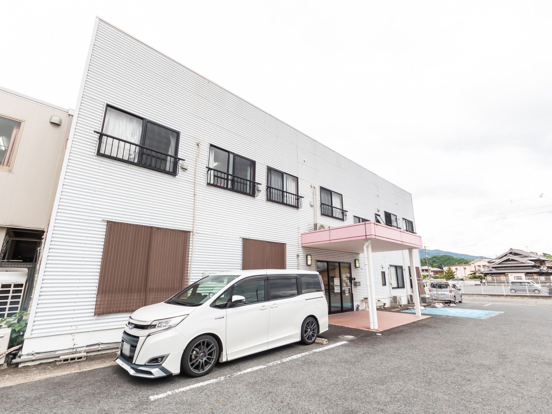 白い建物と駐車場