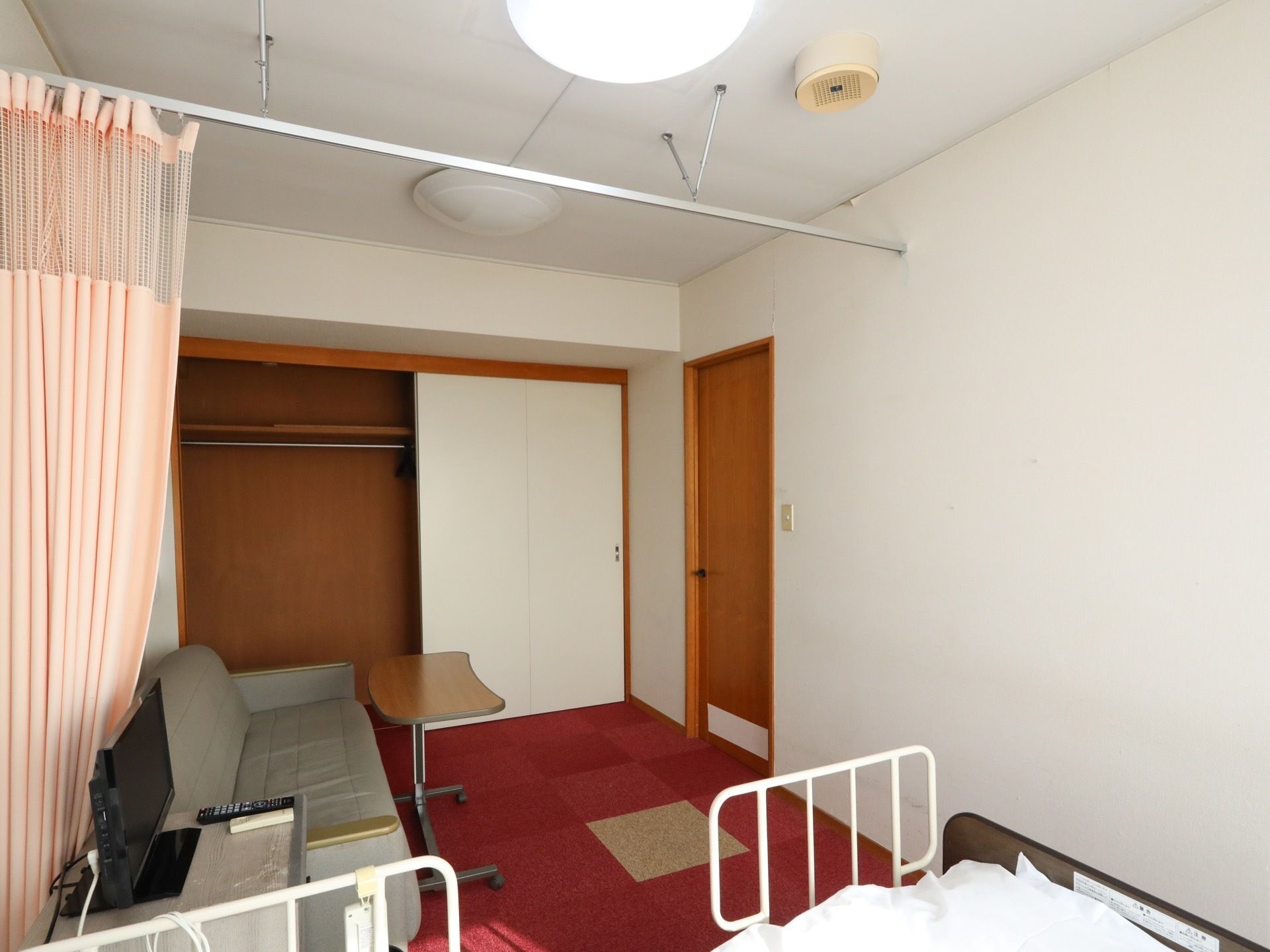 部屋の天井にはカーテンレールが敷かれ、ベッドとソファーを別空間に分けられるようなデザイン