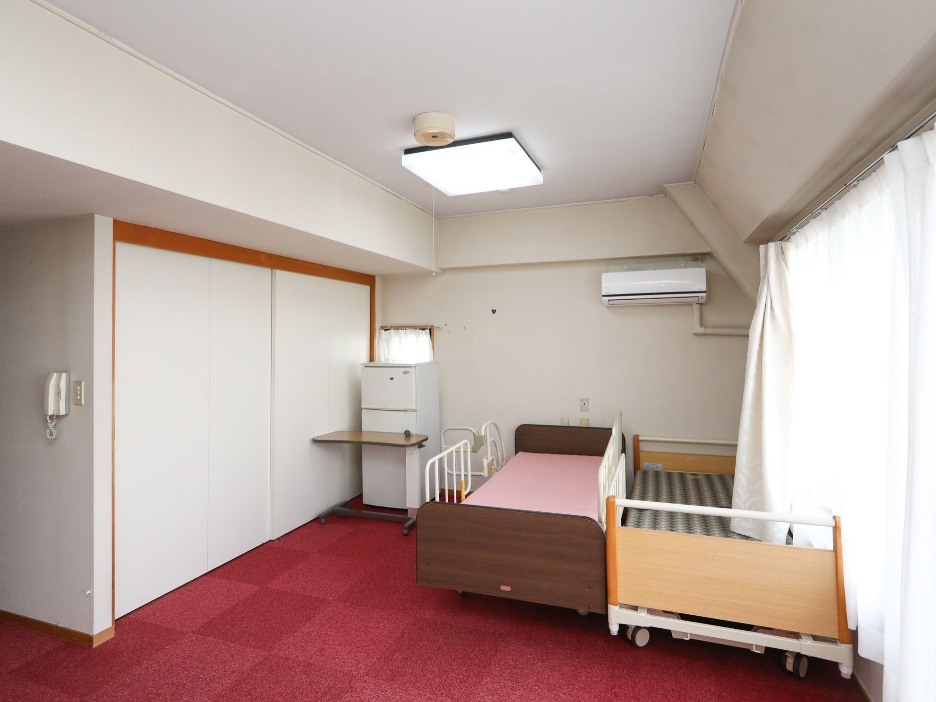 居室には安全対策として、両サイドに転落防止柵のあるベッドを完備