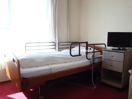 大きな窓があり明るい雰囲気。居室には、ベッドや収納家具だけでなくテレビもついている。