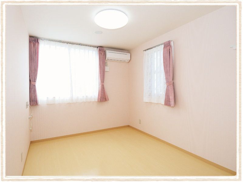 二つの窓にはレースカーテンとカーテンが付き、フローリングの広い部屋には家具や家電は置かれていない。