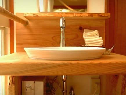 木と陶器の組み合わせで作られた洗面台の写真。フットレス設計の洗面台