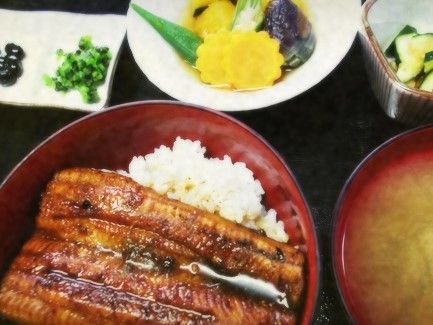 うな丼と漬物、小鉢などが用意されたメニューの写真