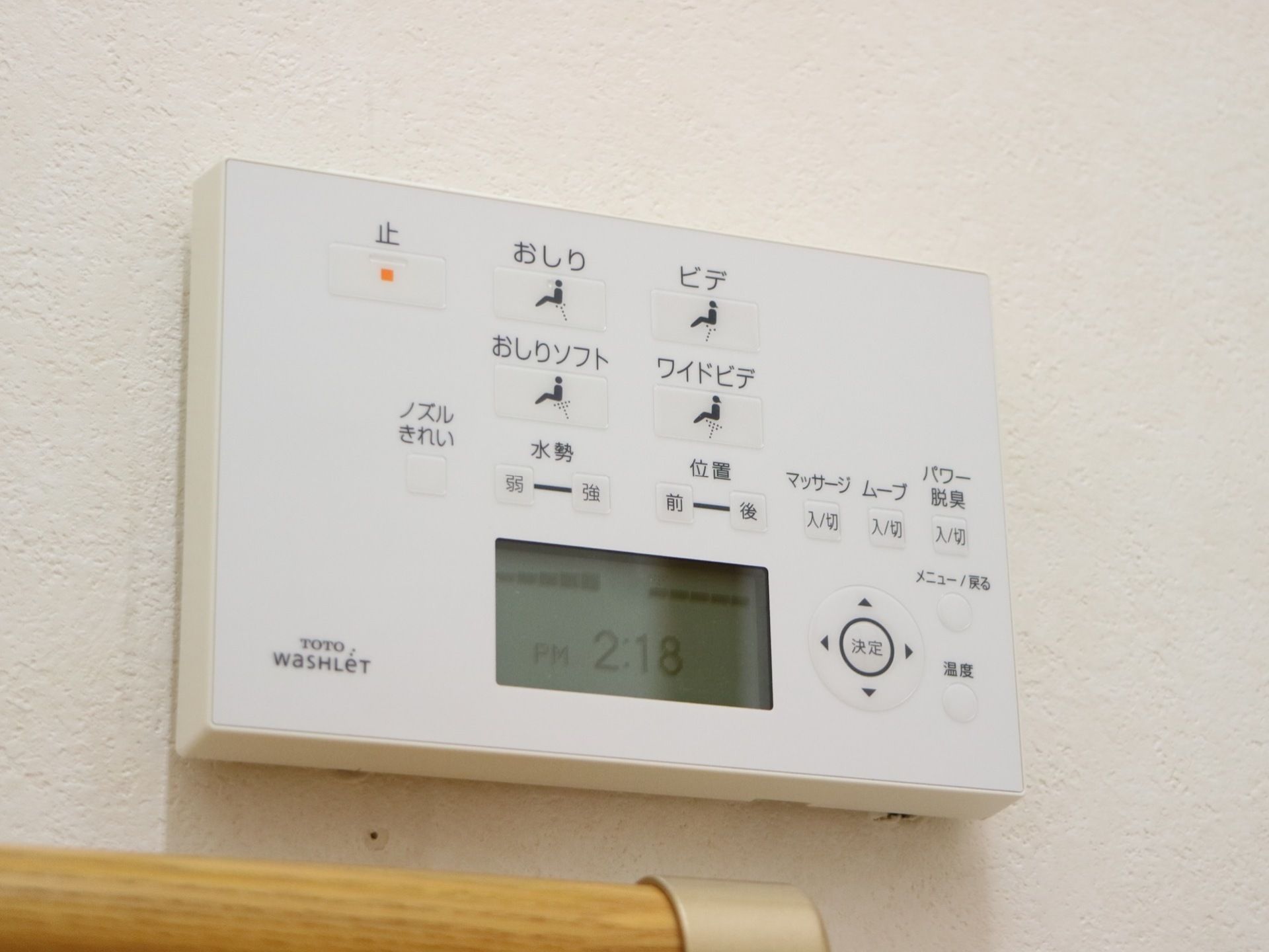 トイレの便座の機能を操作するパネルが、手すりの少し上に取り付けられている。日本のメーカーの製品である。
