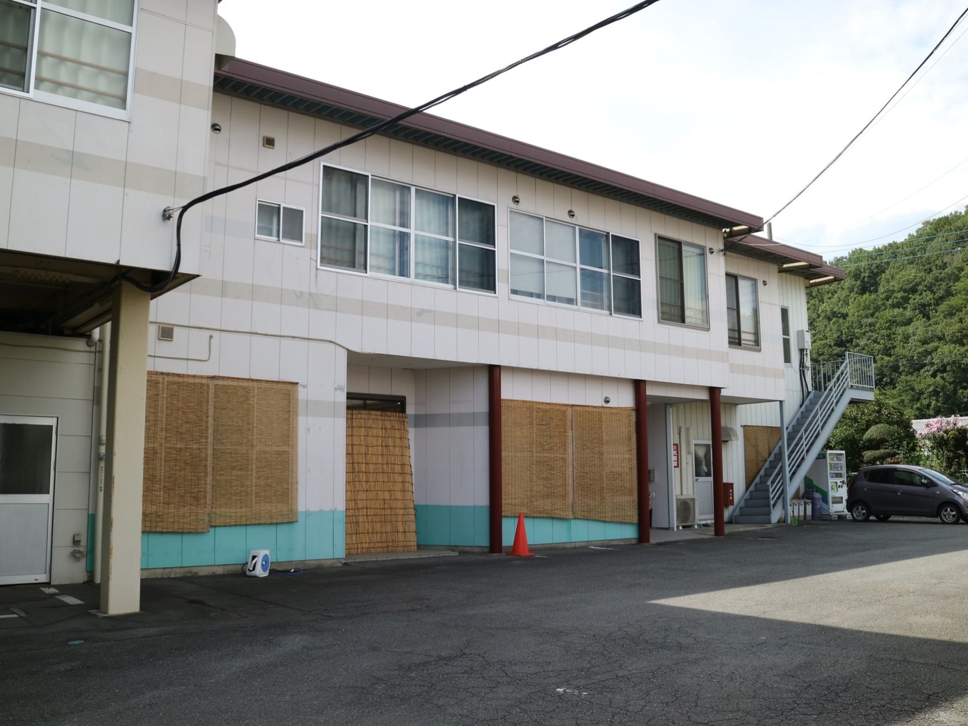 白色を基調とした外壁を持つ２階建ての施設である。２階から敷地面までつながっている、手すりがついた外階段がある。